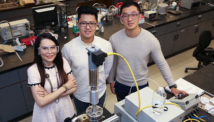 three people standing in a lab