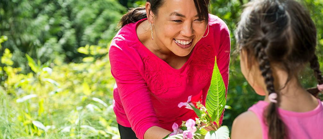 Daughter giving mother flowers