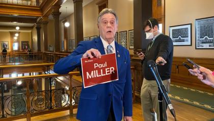 Man holding sign in front of reporters. from the article What's ON: The week that was in Ontario politics (March 21-March 25)